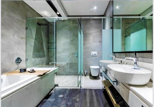 a bathroom with a sink and a shower and a toilet at The RoyalPlatinum Penthouse in Johannesburg