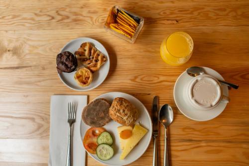 a table with two plates of breakfast foods and a cup of coffee at ANC Resort in Caloura