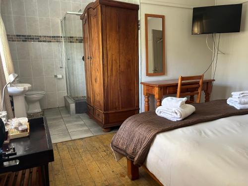 a bedroom with a bed and a bathroom with a shower at Pebble Fountain Guesthouse in Pretoria