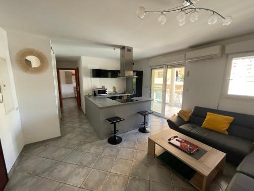 un salon avec un canapé et une cuisine dans l'établissement Immeuble le Mozart, à Ajaccio