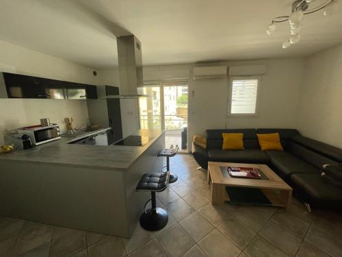 un salon avec un canapé et une cuisine dans l'établissement Immeuble le Mozart, à Ajaccio