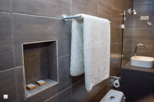 a bathroom with a toilet and a sink and towels at Hotel le Pelican in Lomé