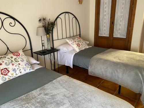 a bedroom with two beds and a table with a lamp at Casa Nemesio, enclave y vistas excepcionales in Valderrobres