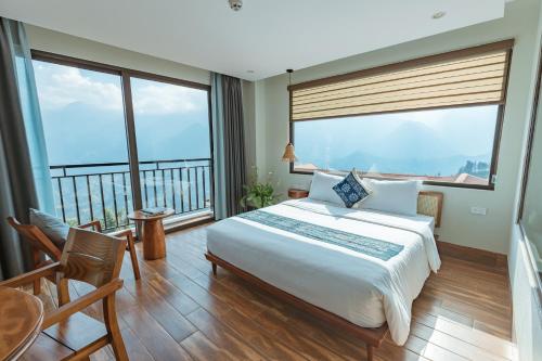 a bedroom with a large bed and large windows at Sapa Yen Hotel in Sa Pa