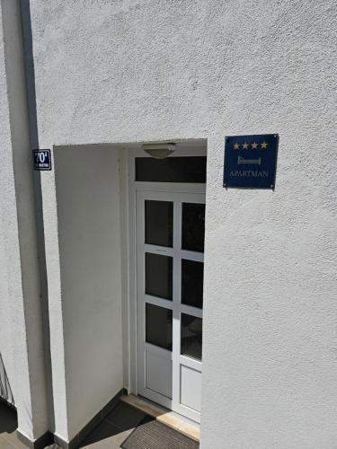 eine Tür zu einem Gebäude mit einem Schild darüber in der Unterkunft Apartment Hajdi in Podstrana