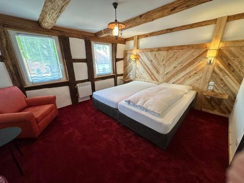 a bedroom with a bed and a chair in it at 1852 Landgasthof in Elze