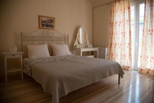 a bedroom with a bed and a large window at Veranda Home in Petrití