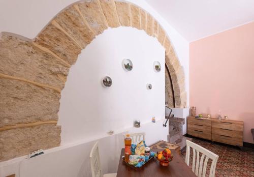 a dining room with an archway and a table and chairs at La Casetta di Giò! in Castellammare del Golfo