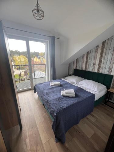 a bedroom with a bed with two towels on it at CZARNY BARAN in Dębki