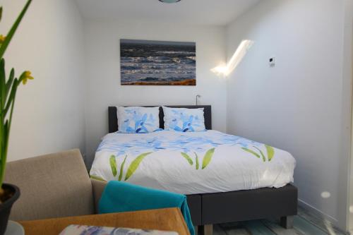 a bedroom with a bed with blue pillows at Studio Eb in Egmond aan Zee
