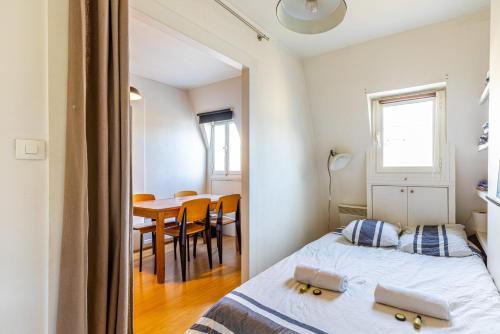 a bedroom with a bed and a table with chairs at GuestReady - Spacious Bright flat near Louvre in Paris