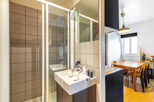 a bathroom with a sink and a shower and a table at GuestReady - Spacious Bright flat near Louvre in Paris