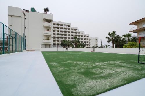 a green lawn in front of a building at Ibersol Almuñecar Beach & Spa Hotel in Almuñécar
