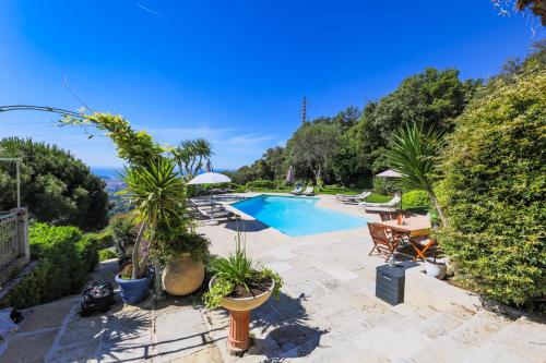 une maison avec une piscine et une terrasse ornée de plantes dans l'établissement LOU MAS SOUBRAN VI2083 by RIVIERA HOLIDAY HOMES, à Nice