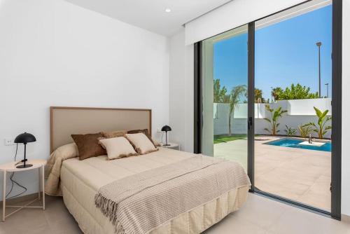 a bedroom with a bed and a large sliding glass door at Luxury Villa Pilar De La Horadada in Pilar de la Horadada