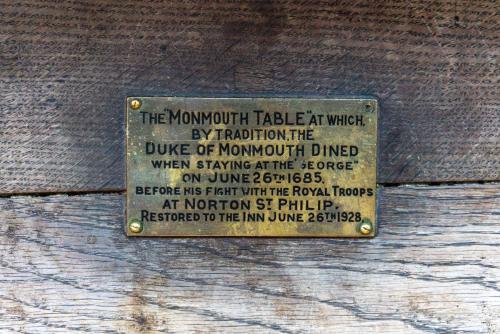 a plaque on a wooden door with a sign on it at The George Inn & Plaine in Norton Saint Philip