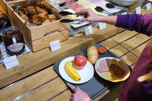 a person reaching for a plate of food on a table at Ibis Budget Bilbao City in Bilbao