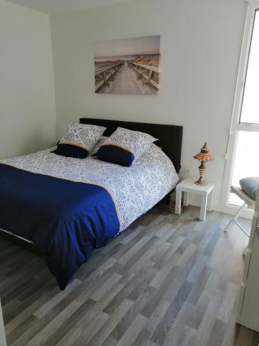 une chambre avec un lit avec une couette bleue dans l'établissement Domaine de la lumière, à Saint-Jean-de-Monts