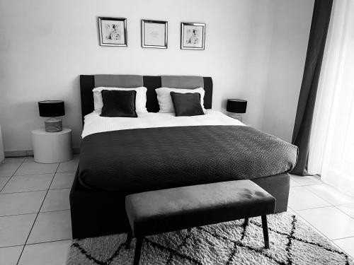 a black and white bedroom with a bed and a chair at LUXURY PENTHOUSE APARTMENT WITH 3 Balconies -2 BEDROOMS & PETRUS VIEW in Luxembourg