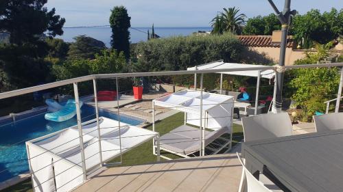 d'un balcon avec des chaises blanches et une piscine. dans l'établissement Villa Andalucia, à La Ciotat