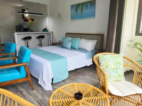 een slaapkamer met een bed, een stoel en een tafel bij Residence Le Point Choisy in Pointe aux Cannoniers