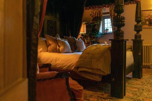a bedroom with a bed with a wooden frame at The George Inn & Plaine in Norton Saint Philip