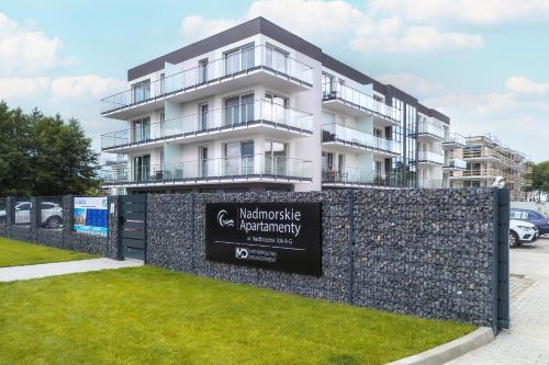 a building with a sign in front of it at 5 minut do Plaży - Apartament MORZETU z Tarasem by Renters in Gąski
