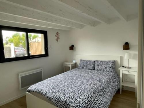 une chambre blanche avec un lit et une fenêtre dans l'établissement Maison Contemporaine Andernos, à Andernos-les-Bains