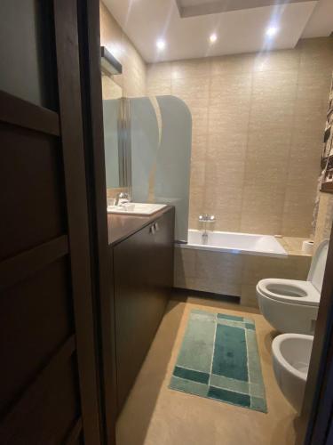 a bathroom with a toilet and a sink and a tub at Stylowy Apartament in Warsaw