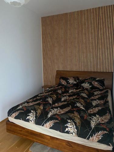 a bedroom with a bed with a wooden headboard at Stylowy Apartament in Warsaw