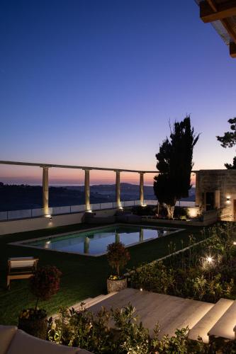 a swimming pool with a view of the ocean at night at Elysian Fields in Mġarr