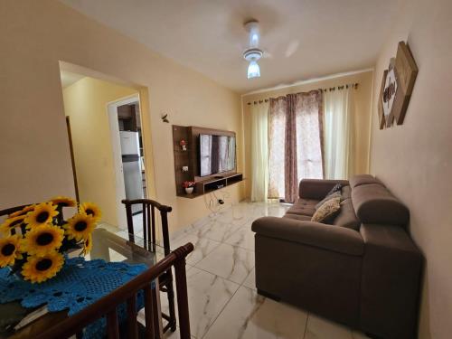 a living room with a couch and a glass table at 095 Tupi Vista Mar I - Tupi - 30 metros da praia - 1 dormitório com VARANDA - Wi fi e acomoda até 5 pessoas - Estacionamento Gratuito ap.95 in Praia Grande