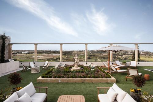 a patio with chairs and a statue and a fountain at Elysian Fields in Mġarr
