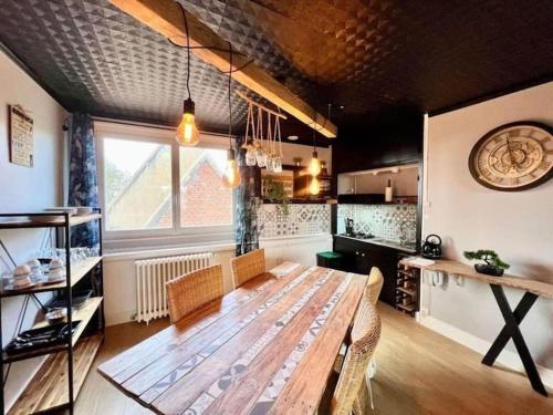 une cuisine avec une table en bois et une grande fenêtre dans l'établissement Domaine Les Tourelles 4, à Caffiers
