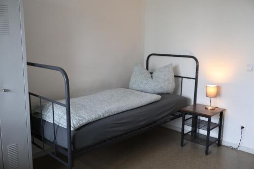 a bed in a room with a lamp on a table at A2rooms in Lehnin