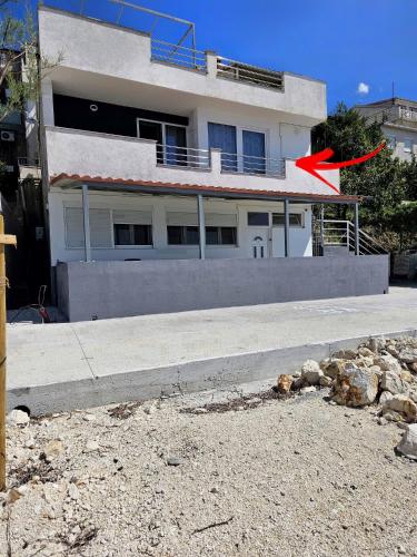 a building with a red arrow in front of it at Apartment Hajdi in Podstrana
