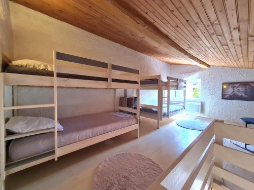 um quarto com beliches num quarto com tecto em madeira em Paisible maison à l'ombre des pins em Fitou