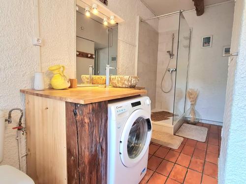 uma máquina de lavar roupa na casa de banho com um chuveiro em Paisible maison à l'ombre des pins em Fitou
