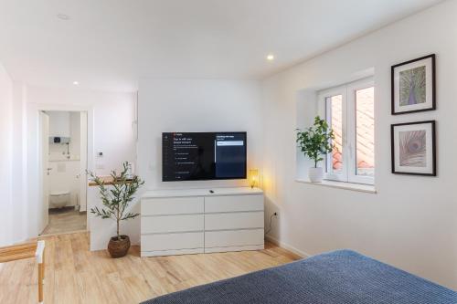 a living room with a flat screen tv on a white dresser at Room Odin in Dubrovnik