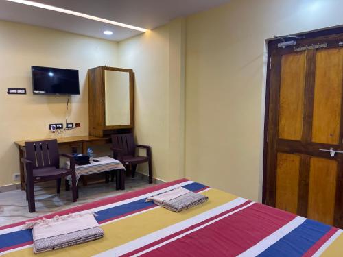 Zimmer mit einem Bett, einem Tisch und einem Spiegel in der Unterkunft Nimmu House in Gokarna