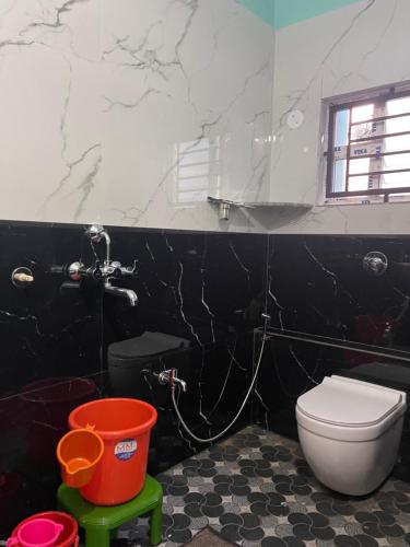 a black and white bathroom with a toilet and a mirror at Nimmu Guest House & Restaurant Gokarna in Gokarna
