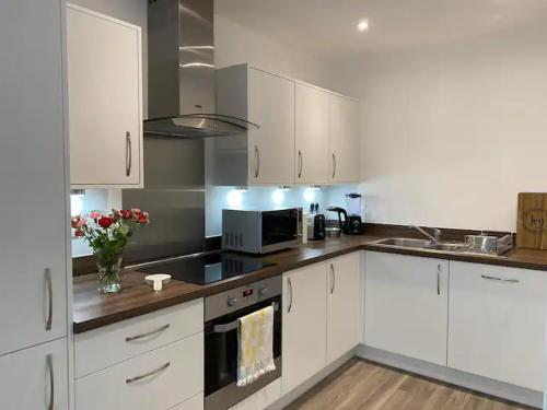 a kitchen with white cabinets and a counter top at Private Room Near Stansted Airport in Bishops Stortford