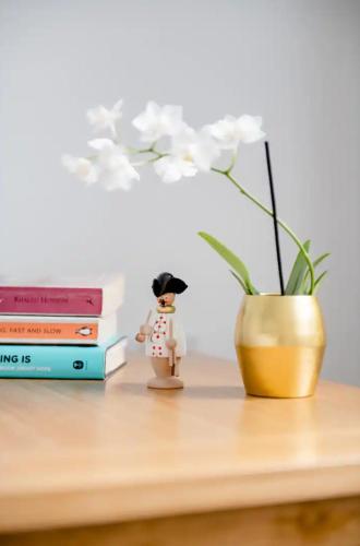 a figurine sitting on a table next to a stack of books at Private Room Near Stansted Airport in Bishops Stortford