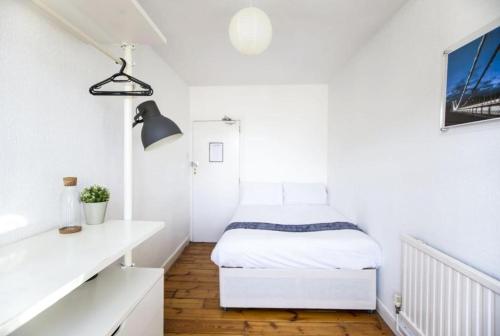 un pequeño dormitorio blanco con una cama. en Arlington Villas Townhouse by Clifton Short Lets, en Bristol