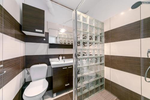 a bathroom with a toilet and a sink and a shower at Warsaw Concierge Grójecka View in Warsaw