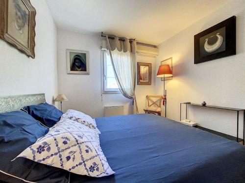 um quarto com uma cama com lençóis azuis e uma janela em Le Stadium - 2 pers - Proche Centre - Mouans-Sartoux em Mouans-Sartoux