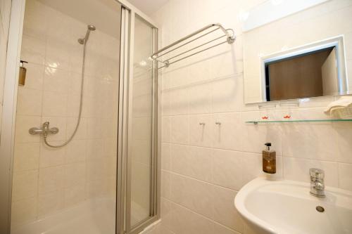 ein Bad mit einer Dusche und einem Waschbecken in der Unterkunft LH Hotel Mědínek Old Town in Kutná Hora