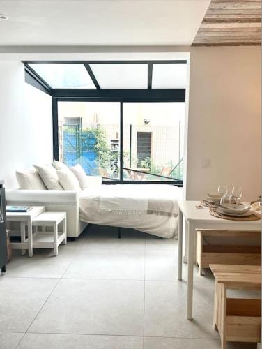 un salon avec un lit et une grande fenêtre dans l'établissement Charmant appartement, atypique, proche du centre, à Antibes