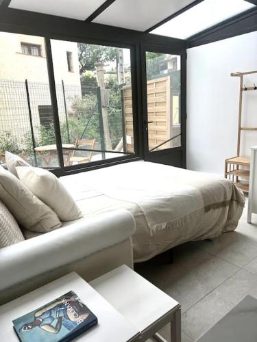 un salon avec un lit et un canapé dans l'établissement Charmant appartement, atypique, proche du centre, à Antibes