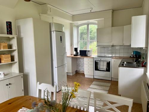 a kitchen with white appliances and a wooden table at Skeppsdockans Vandrarhem in Söderköping